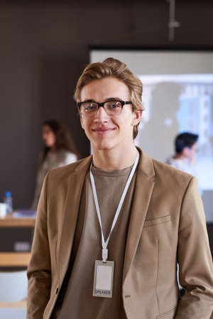 Portrait of young businessman in eyeglasses looking at camera while visiting business presentationの写真素材