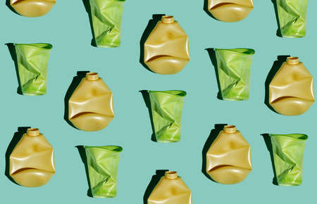 Modern flat lay pattern of crumpled plastic bottles and cups on light blue background, conscious consumption and plastic waste conceptの写真素材