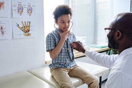 African little boy in stethoscope listen to his heartbeat with doctor during medical exam at hospitalの写真素材
