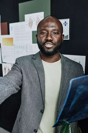 Portrait of African male radiologist working with x-ray images at office