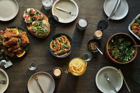 High angle view of dining table served with various dish and appetizers for party dinner