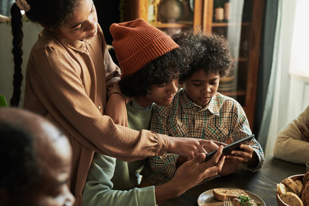 Group of children playing online video game together on tablet pc while sitting at dining table