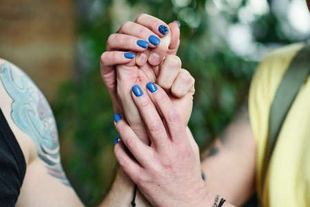 Horizontal close-up shot of unrecognizable woman in love holding hand of her husband, intimacy conceptの写真素材