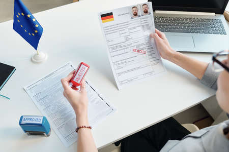 High angle view shot of unrecognizable consular officer rejecting and approving applications for visaの写真素材