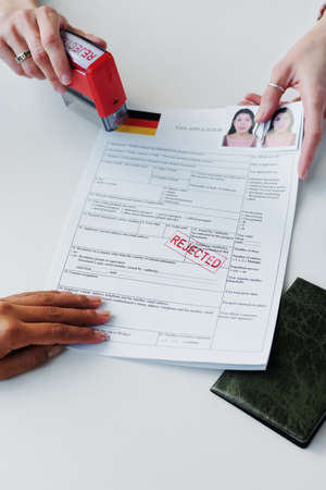 High angle medium close-up of woman having appointment in embassy getting application for visitor visa rejectedの写真素材