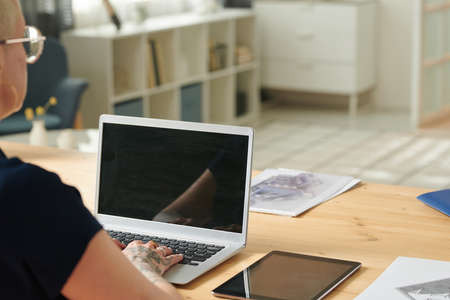 Close-up of architect working over architectural project online at home using her laptop