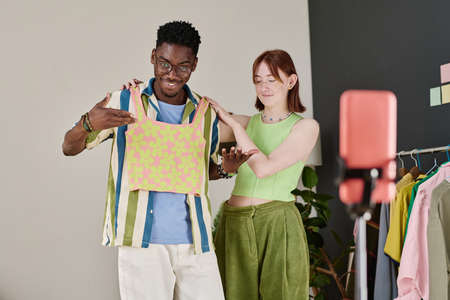 Couple of young bloggers making content together talking to their followers about style during...