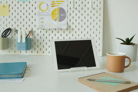 Close-up of digital tablet with notepad and cup of coffee on desk of business person at office
