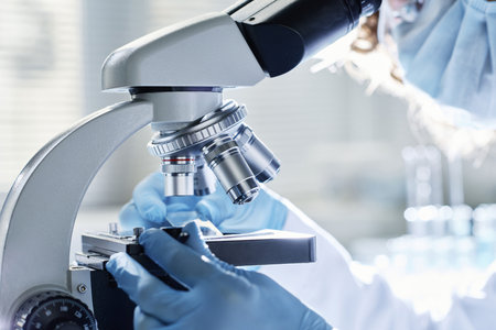 Gloved hands of young modern scientist preparing all the necessary equipment before carrying out new...