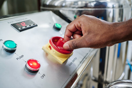 Close-up of engineer operating equipment with panel for processing chemical material in factory