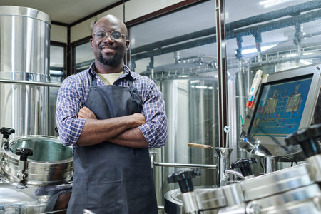 Portrait of African American engineer smiling at camera standing with his arms crossed, he working...