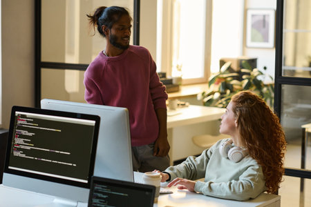Young programmers working in team in IT office, they discussing codes for new computer software