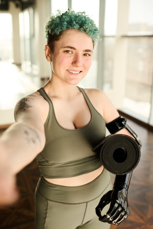 Portrait of young woman with disability making selfie portrait while training in gymの写真素材