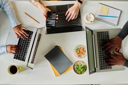 Top view of group of programmers working online on computers at table, they writing codes for programの写真素材