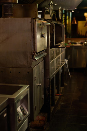Metallic electric equipment for baking and grilling standing in spacious kitchen of cafe, restaurant, bar or some other place for having snackの写真素材