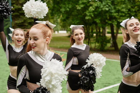 Group of cheerleading girls dancing outdoors at sport competition