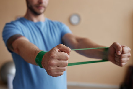 Close-up of young man training with rubber band during his rehabilitationの写真素材
