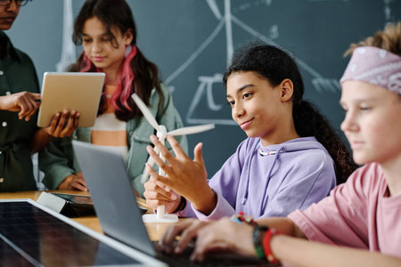Group of students using computers and learning the work of windmill together with teacherの写真素材
