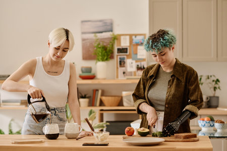 Lesbian couple preparing breakfast and making coffee together in the kitchenの写真素材