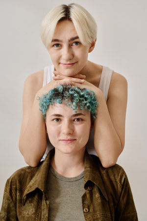 Vertical portrait of young couple of lesbian looking at camera against white backgroundの写真素材