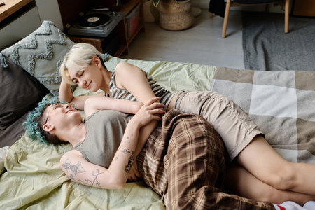 High angle view of girls having leisure time at home, they lying on bed and enjoying time togetherの写真素材