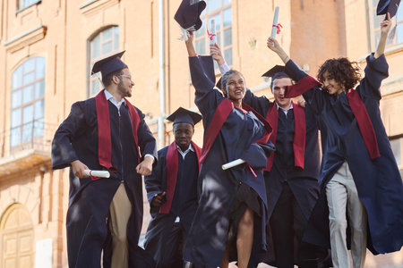 Happy graduated students in robes celebrating their graduation from universityの写真素材