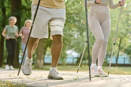 Close-up of couple doing nordic walking with sticks outdoors in the parkの写真素材