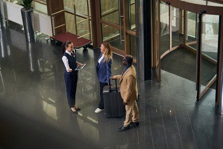 High angle view of manager with digital tablet meeting guests in the hotelの写真素材
