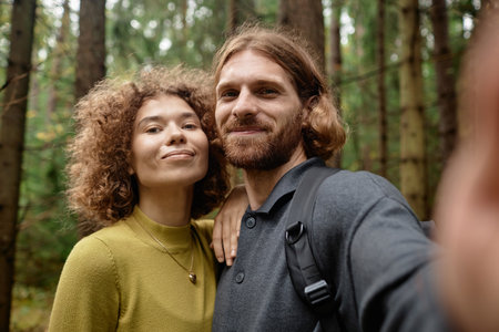 Selfie portrait of young couple smiling at camera during their hiking in the forestの写真素材