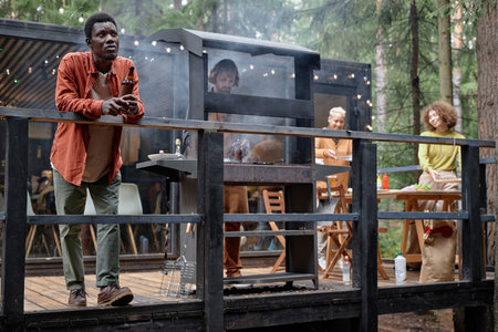 Young friends having picnic party outdoors, they cooking meat and drinking alcohol drinksの写真素材