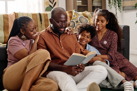 Father of family reading book on Martin Luther King Jr ideas to his wife and two kidsの写真素材