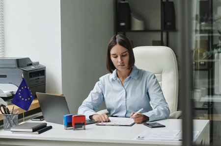 Professional visa service employee working with visa documents at her workplace in office