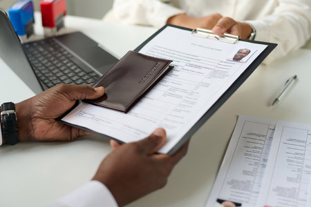 Close-up of man giving documents to specialist to get visaの写真素材