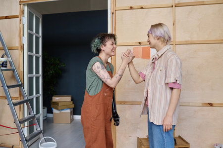Happy girls shaking hands, they choosing color for their future design of apartmentの写真素材