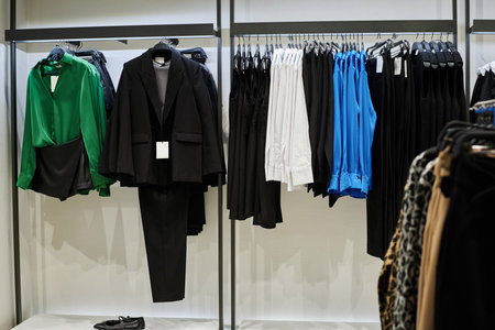 Wide shot of casual clothes put on hangers displayed at mass market fashion store