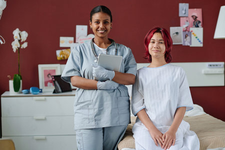 Young successful plastic surgeon with tablet and her teenage patient with liftmarks on face looking...