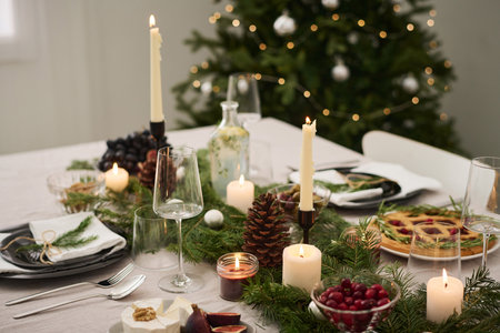 Medium shot of candlelit festive christmas table with decorations and traditional dishesの写真素材