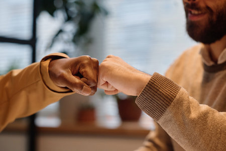 Closeup of hands of biracial men fistbumping each other