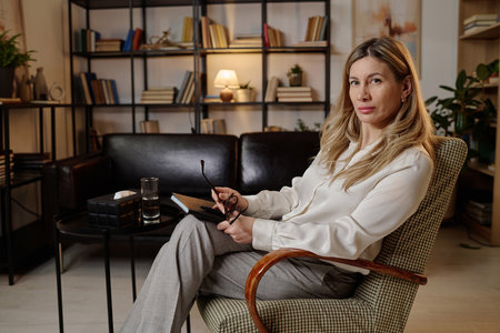 Caucasian female mental health specialist posing at her workplace in office with modern interiorの写真素材