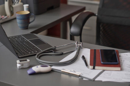 Empty workplace at hospital office with documents and equipment of physician displayed on table