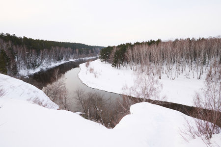No people landscape shot of picturesque mountains, forest and river on frosty winter day