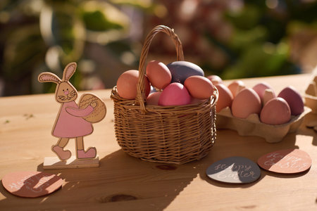 Closeup no people shot of Easter still life composition with colored eggs in basket and rabbit...