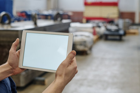 Selective focus shot of unrecognizable factory worker holding digital tablet with blank screen, copy spaceの写真素材