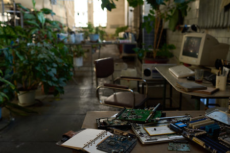 Selective focus no people shot of computer components and tools on table in abandoned factory or workshop building, copy spaceの写真素材