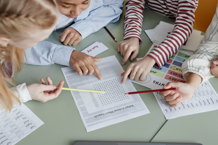 High angle view of boys and girls attending English language class doing task together, copy spaceの写真素材