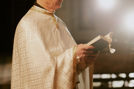 Crop shot of unrecognizable senior Catholic priest wearing liturgical vestment reading Bible, copy spaceの写真素材