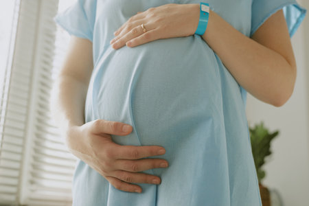 Close up photo of pregnant woman touching her belly and caring about her unborn child