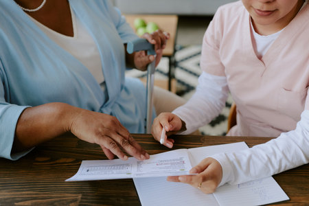 Nurse helping elderly African American woman with filling papers outの写真素材