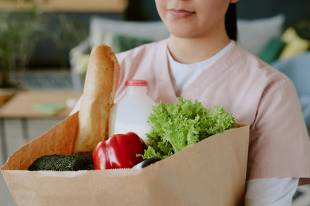 Close up photo of paper bag with wholesome food carried by nurseの写真素材
