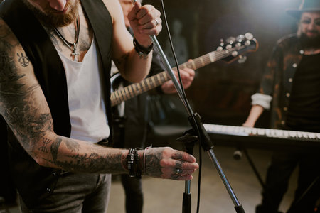 Crop shot of unrecognizable male rock vocalist getting ready for performance adjusting microphone standの写真素材